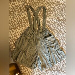 Khaki green cargo shorts with adjustable straps and pockets